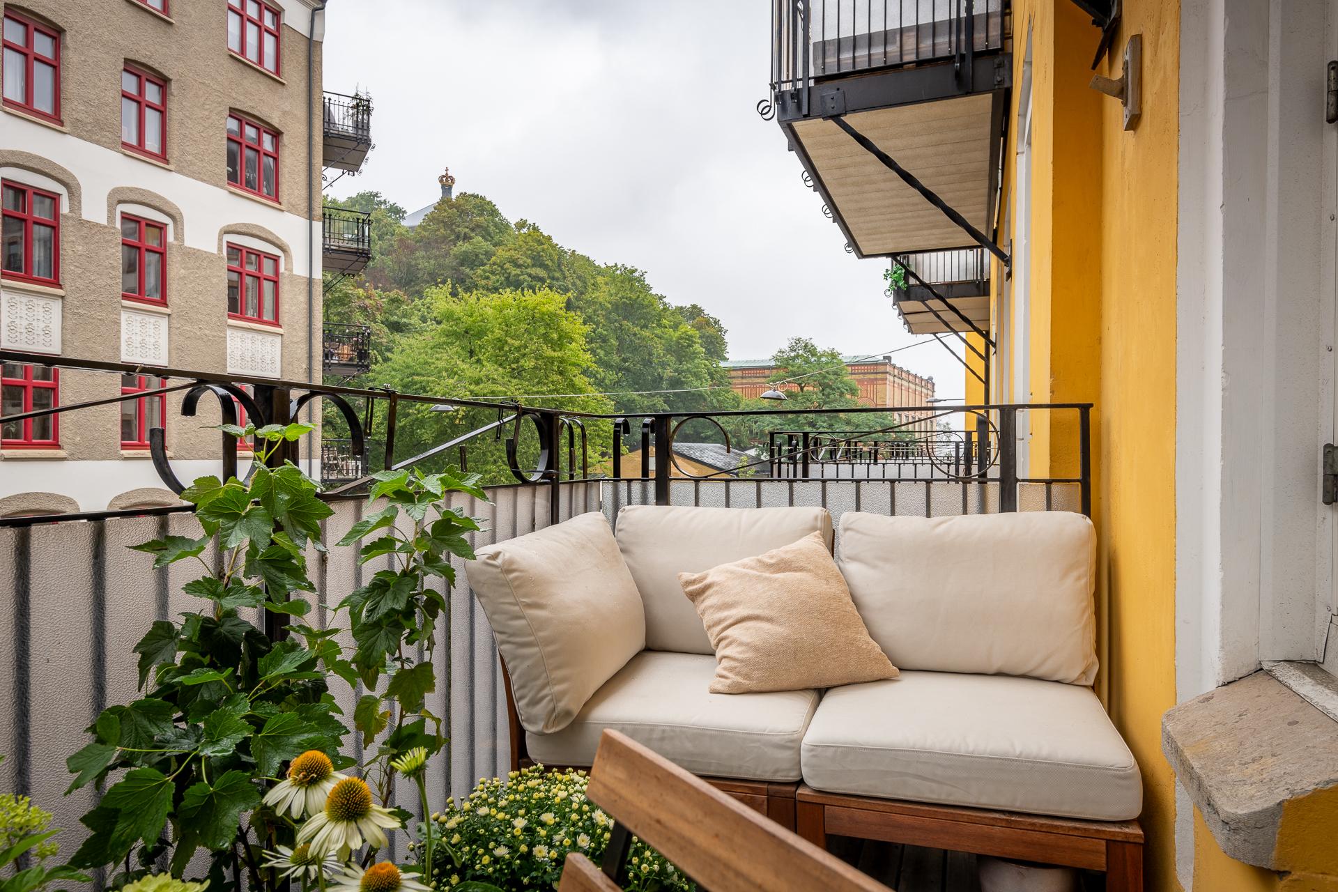 Solig västerbalkong med vy mot grönskan