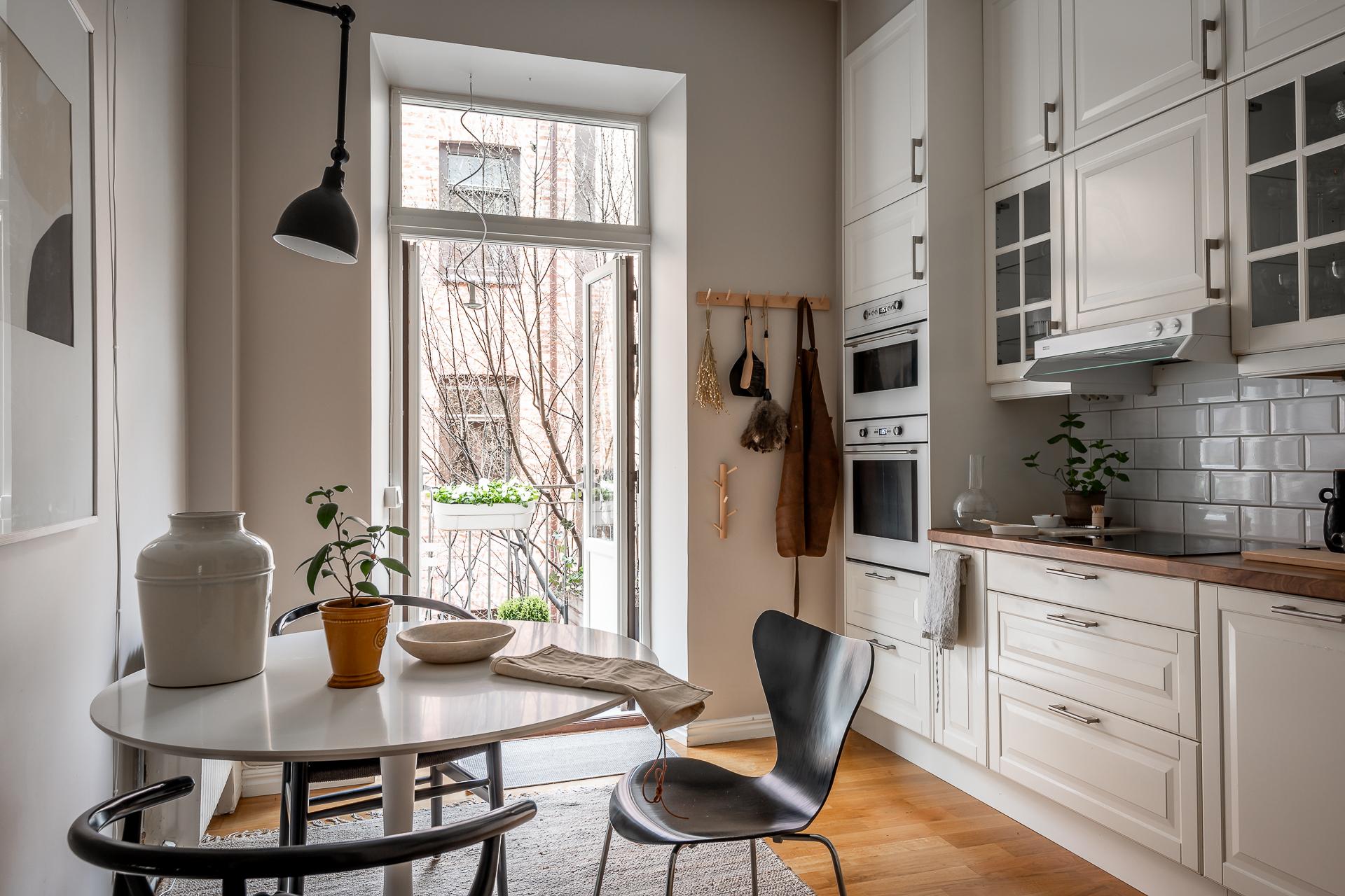 Vackert, tidssmickrande kök med vitrinskåp