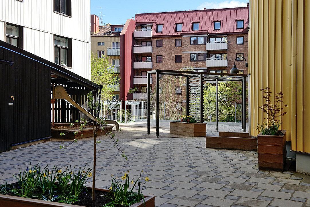 Lågupplöst Renoverad innergård med växter och utemöbler