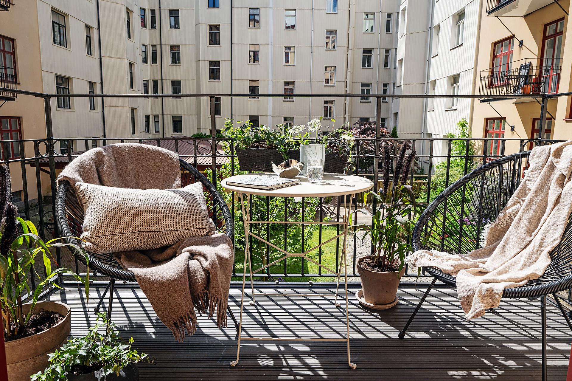 Solig västerbalkong mot lummig innergård