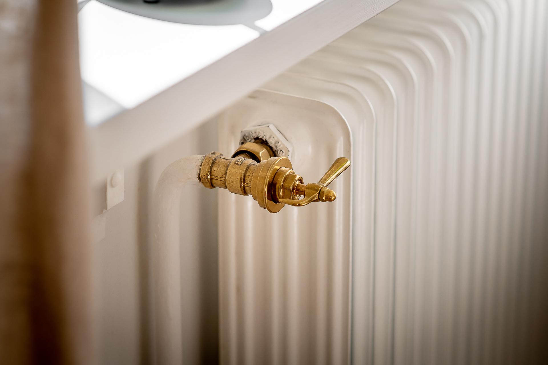 Slottsvred i mässing reglerar temperaturen i de gamla radiatorerna