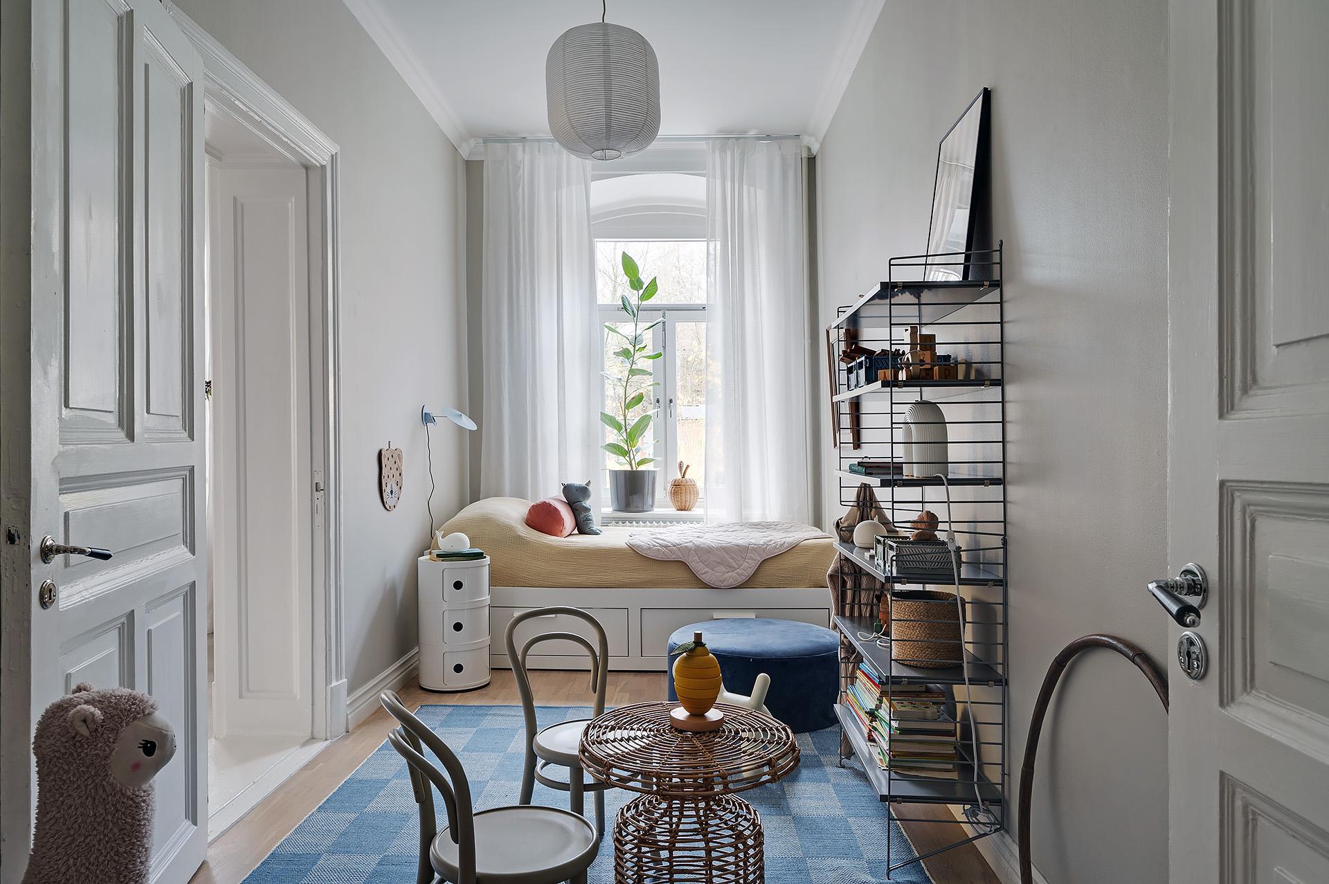 Mysigt barnrum med högt fönster i västerläge