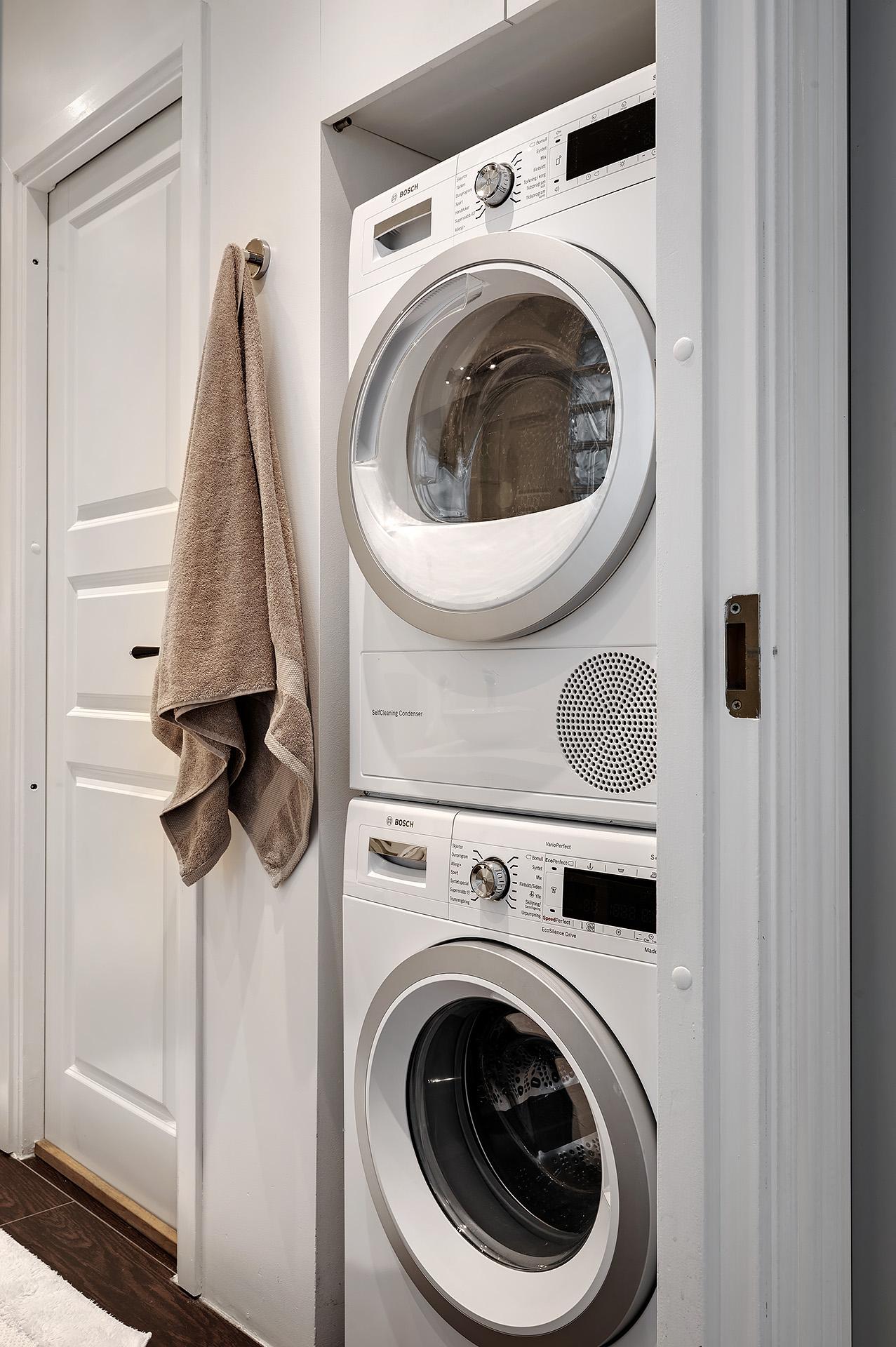Tvättpelare och en dörr som leder in i en walk-in closet