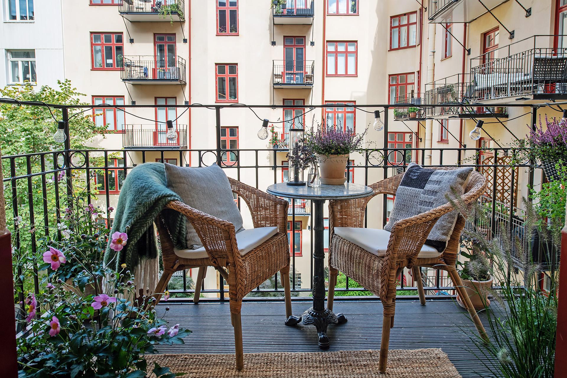 Rymlig smidesbalkong mot den lummiga gården