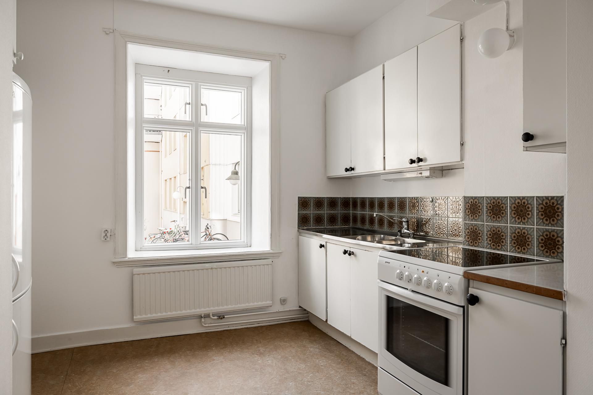 Köket är förhållandevis rymligt och det höga, vackra fönstret släpper i naturligt ljus