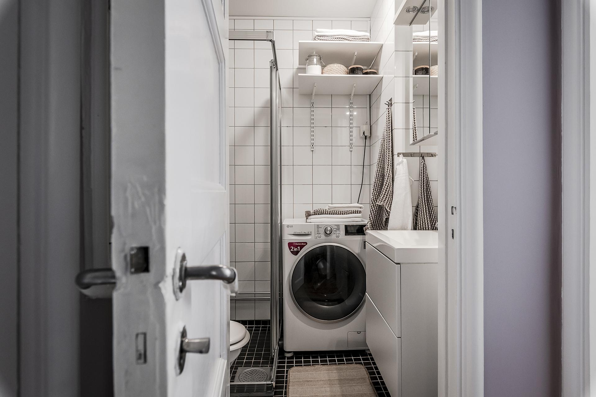 Helkaklat badrum med dusch och tvättmaskin