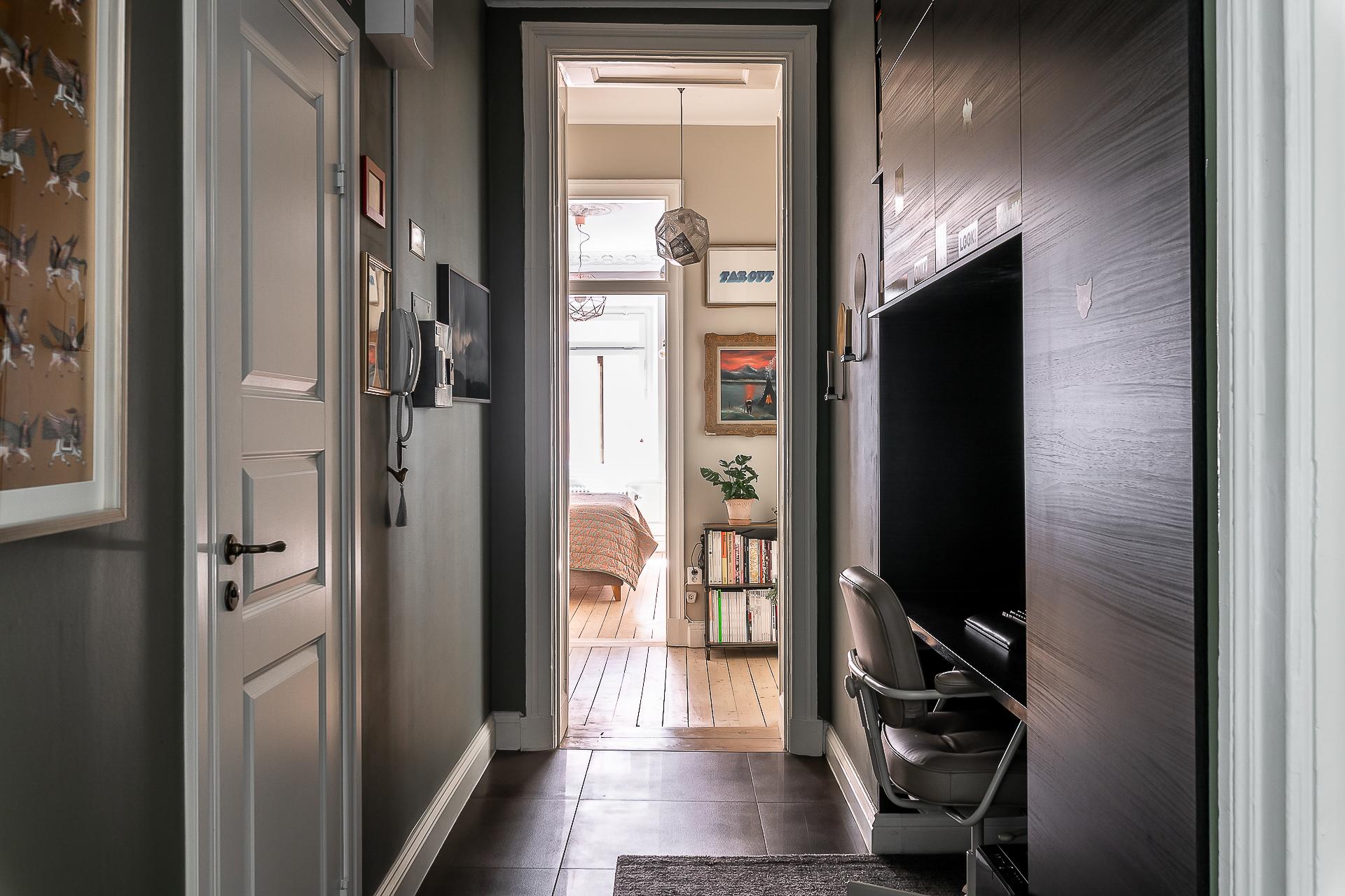 Ett skrivbord har byggts in som är omgivet av skåp som ger massor av förvaringsutrymme.